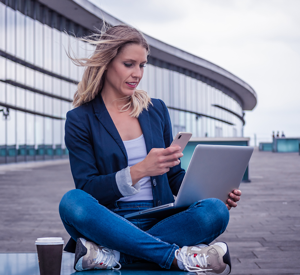 young career woman working outside with her devices